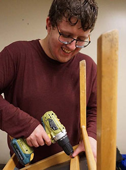 TRU student working with drill assembling a wooden structure